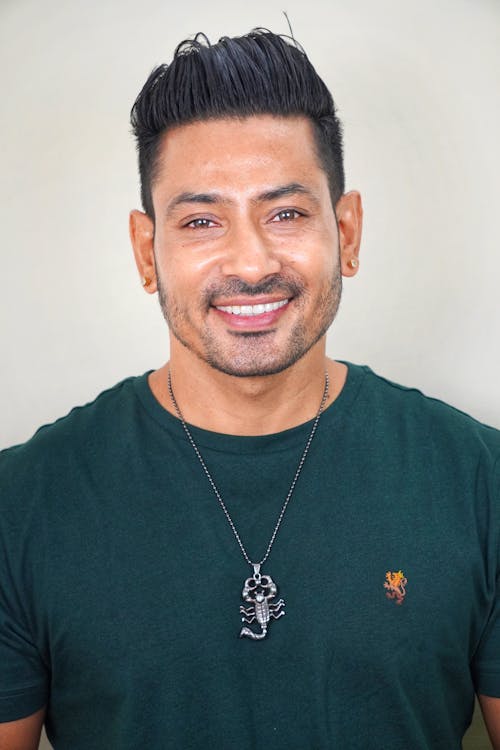 Man in Green Shirt Wearing a Necklace Smiling