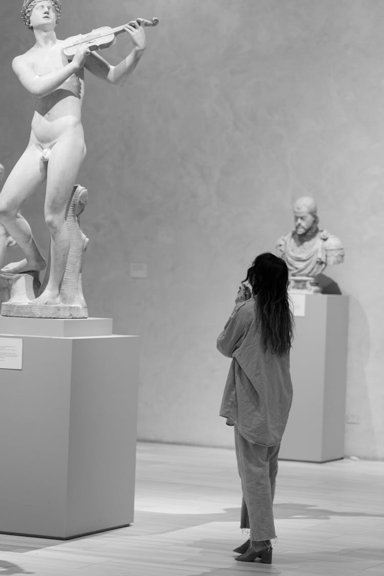 Grayscale Photo Of Woman Looking At The Statue 