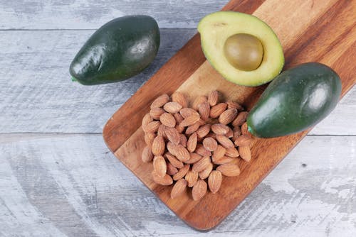 Free Almond Nuts and Avocados on Brown Wooden Chopping Board Stock Photo