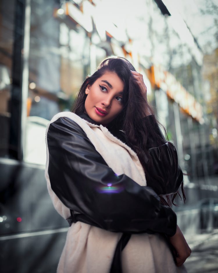 A Woman In Black Leather Jacket With White Vest