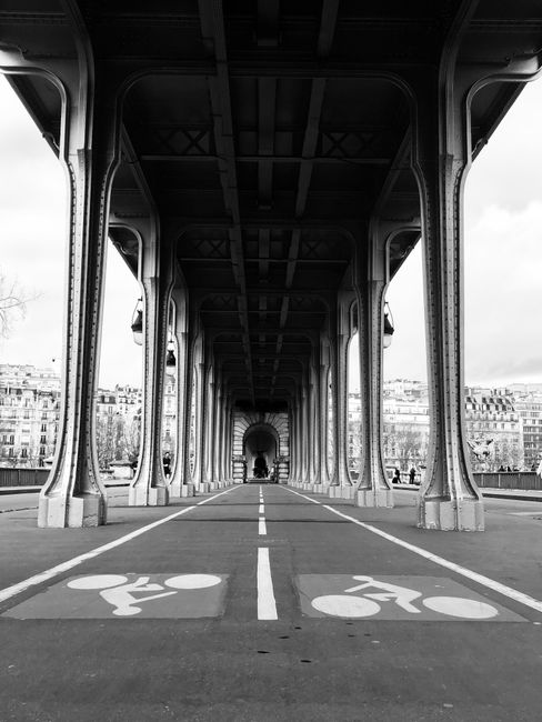 Dramatic black and white shot of Pont de Bir-Hakeim with bike lane in Paris, France.