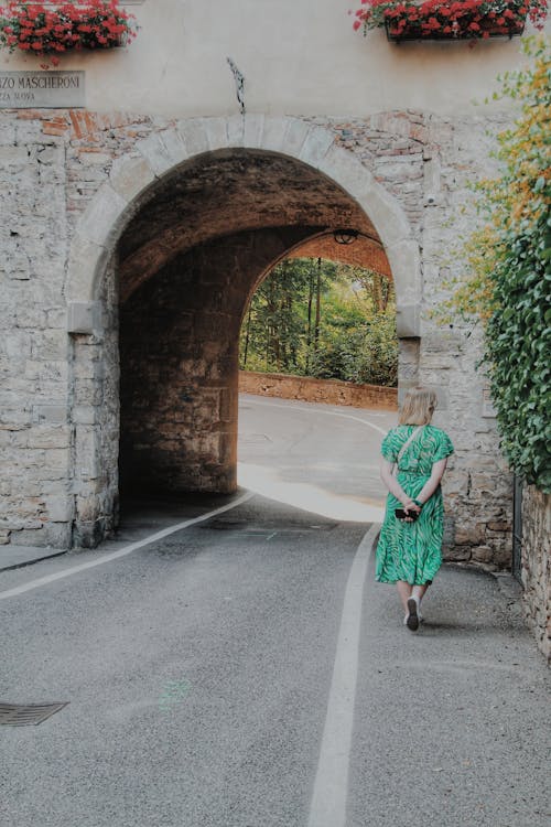A Woman in Green Dress Walking on the Street