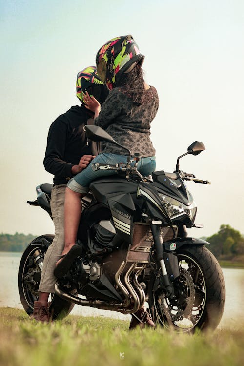 A Man in Black Jacket Riding a Black Motorcycle