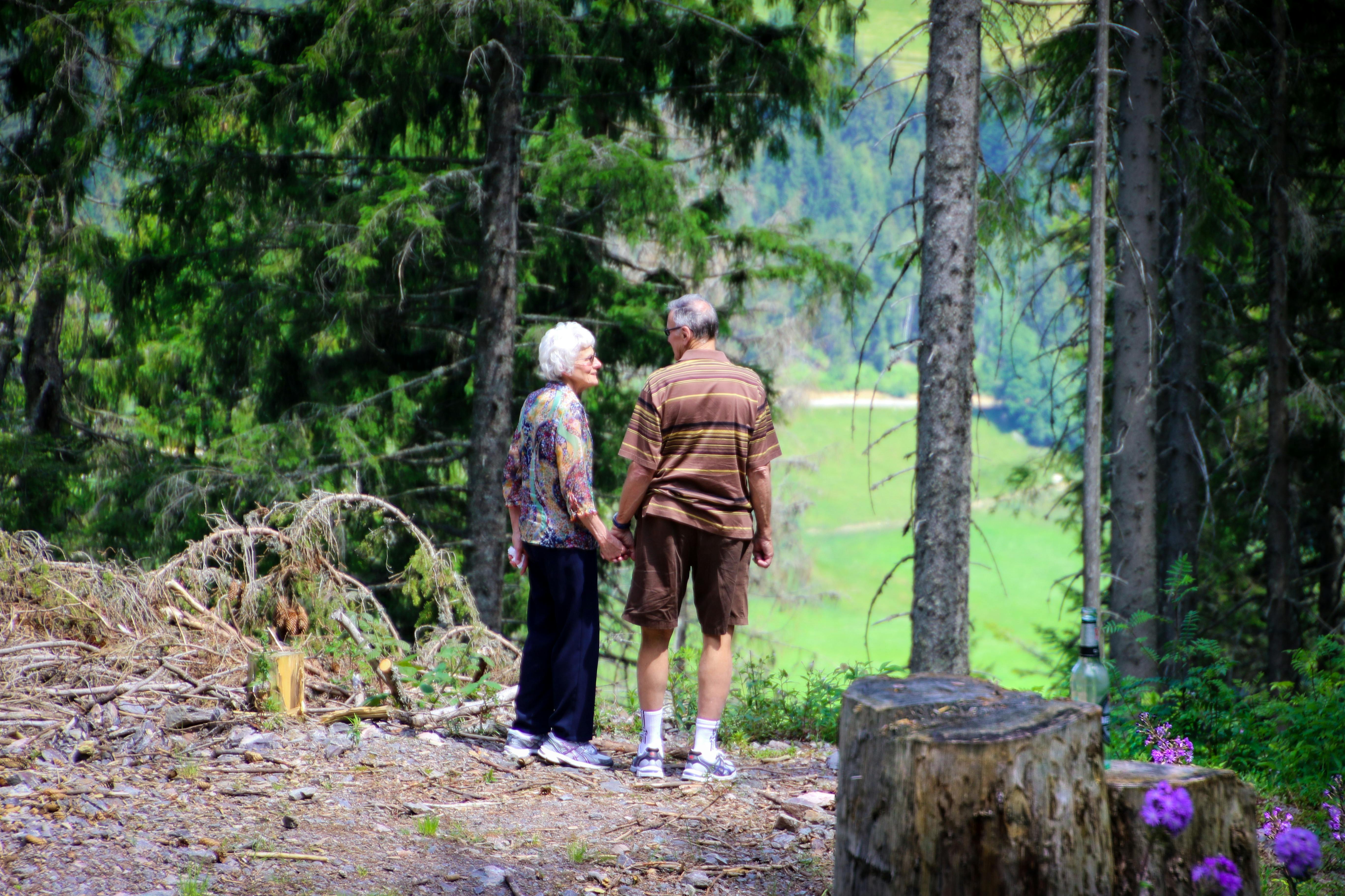 Old couple standing in the forest. | Photo: Pexels