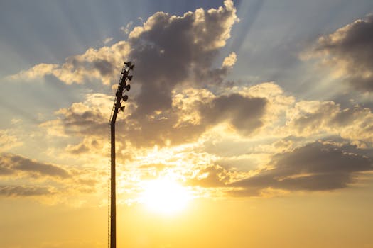 Stadium lights silhouetted against a dramatic sunset sky in Olifantsfontein, South Africa.