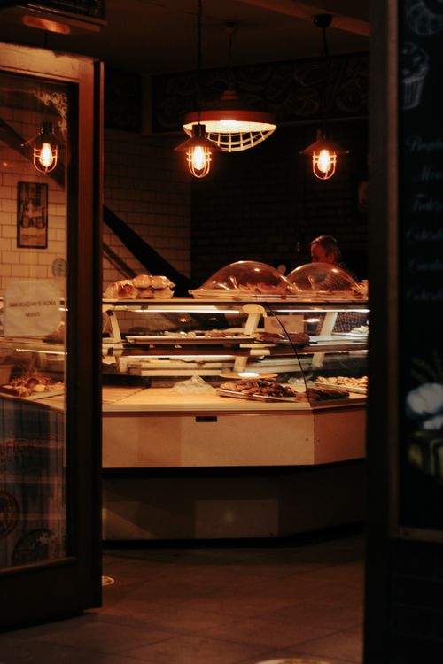 Free Warm-lit bakery counter with fresh baked goods and inviting ambiance. Stock Photo