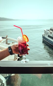 A vibrant drink with an orange slice and straw enjoyed by the sea in İzmir, Turkey.