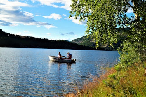 People Rowing a Boat on the Lake