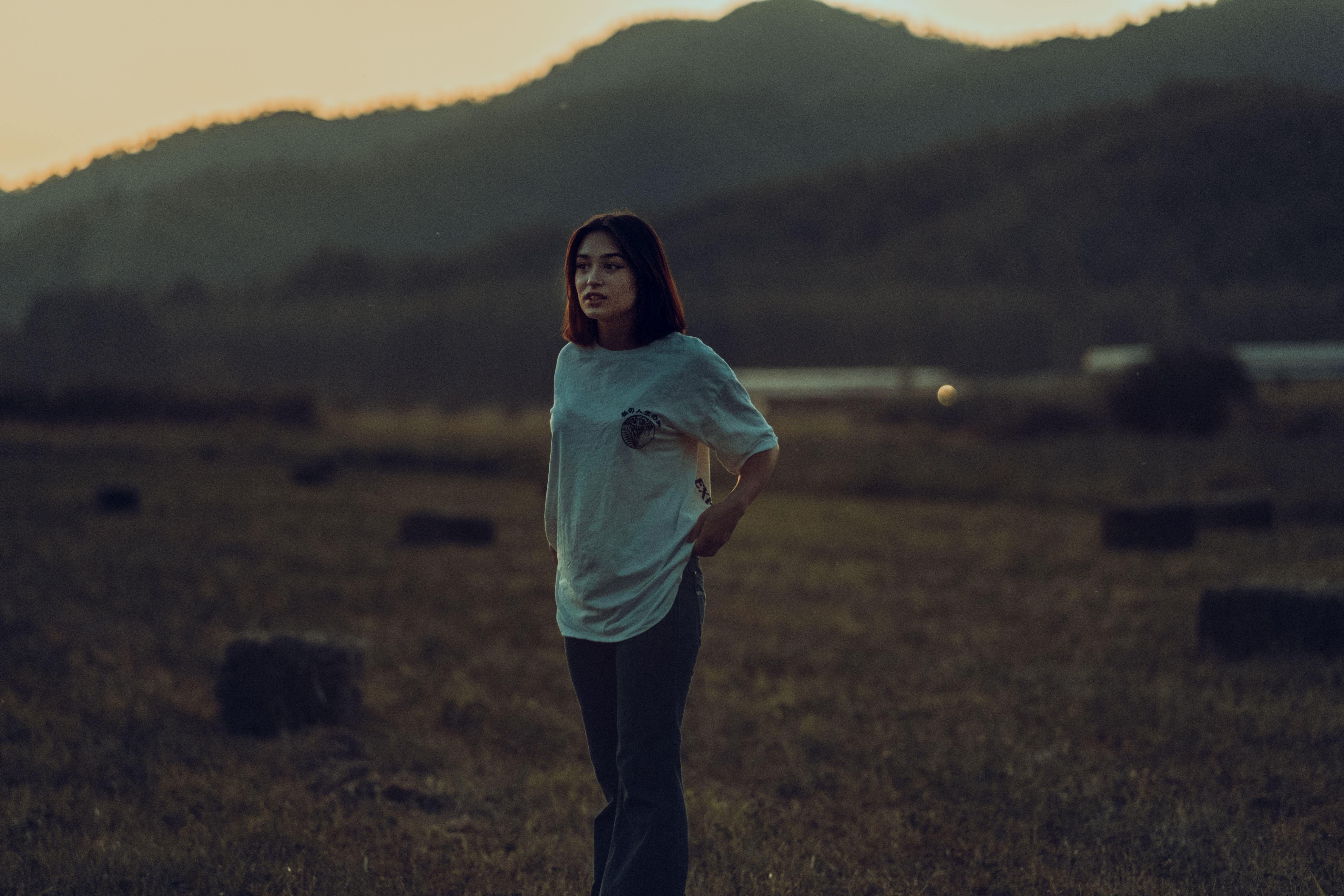 Woman in White Shirt Standing on a Field · Free Stock Photo
