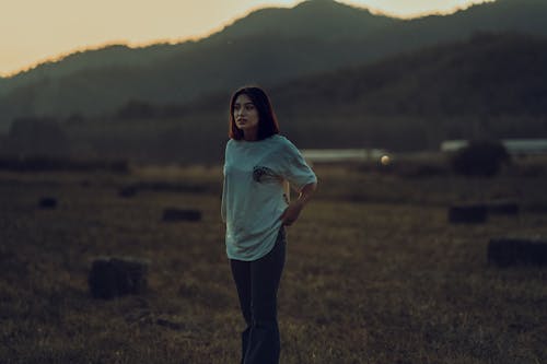 Woman in White Shirt Standing on a Field