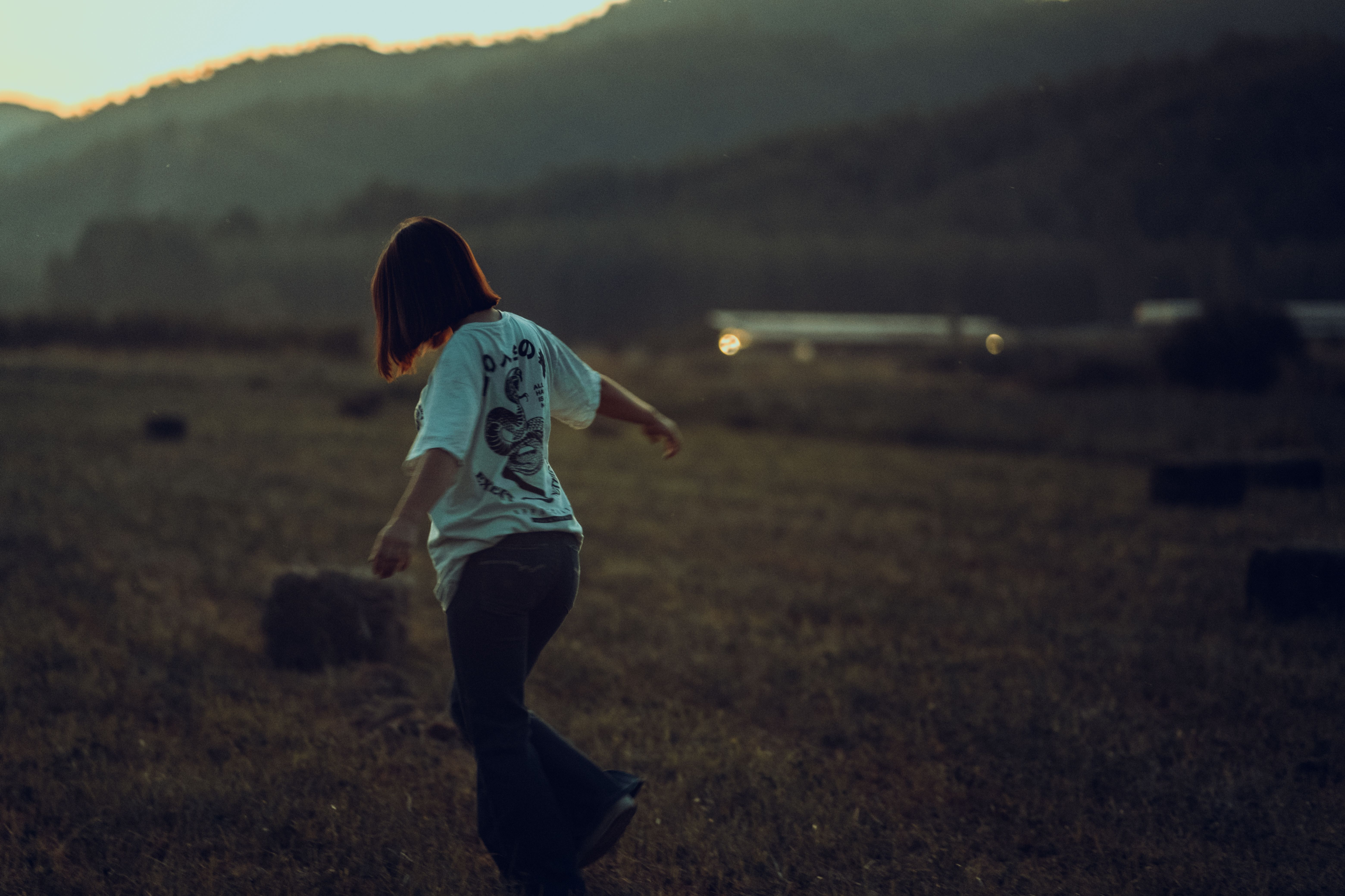 Woman Walking in a Grass Field · Free Stock Photo