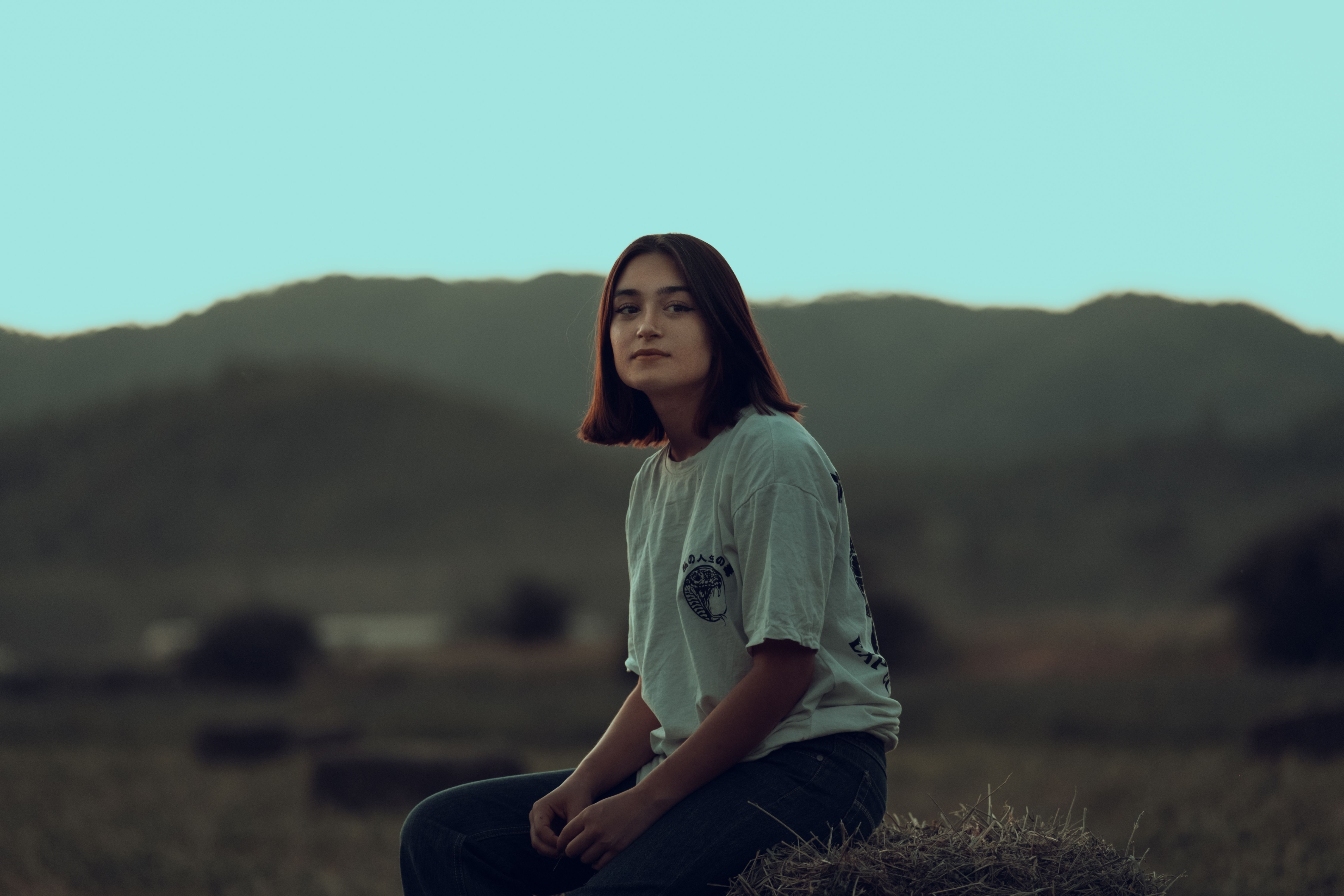 Bej kanguru cepli hoodie giyen genç bir kadın