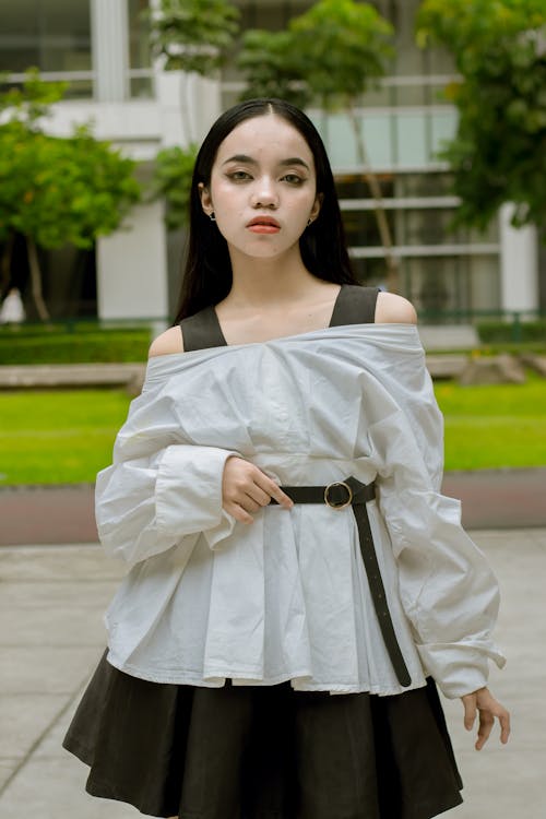A Woman in White Off Shoulder Top Looking with a Serious Face