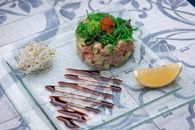Tasty fish tartare with chukka salad and red caviar