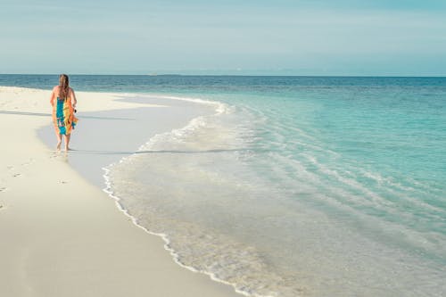 Woman Walking in a White Sand Beach