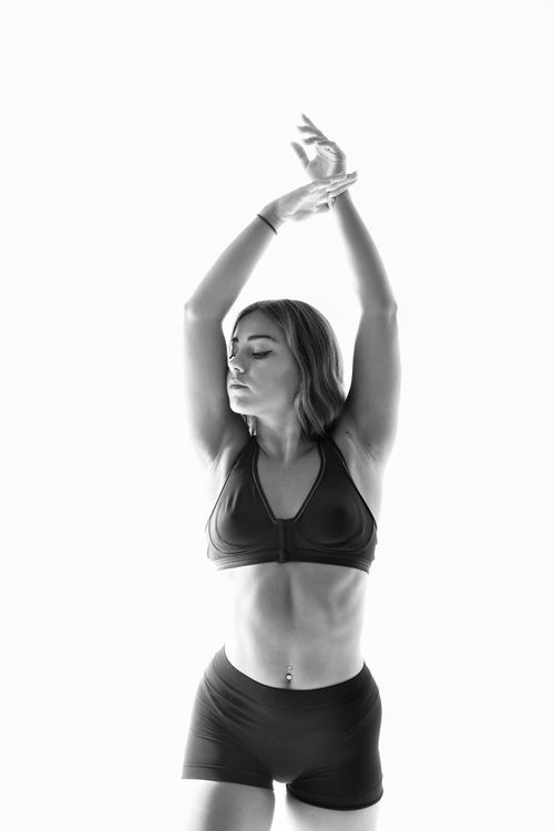 Free Elegant black and white photo of a woman posing gracefully with arms raised. Stock Photo