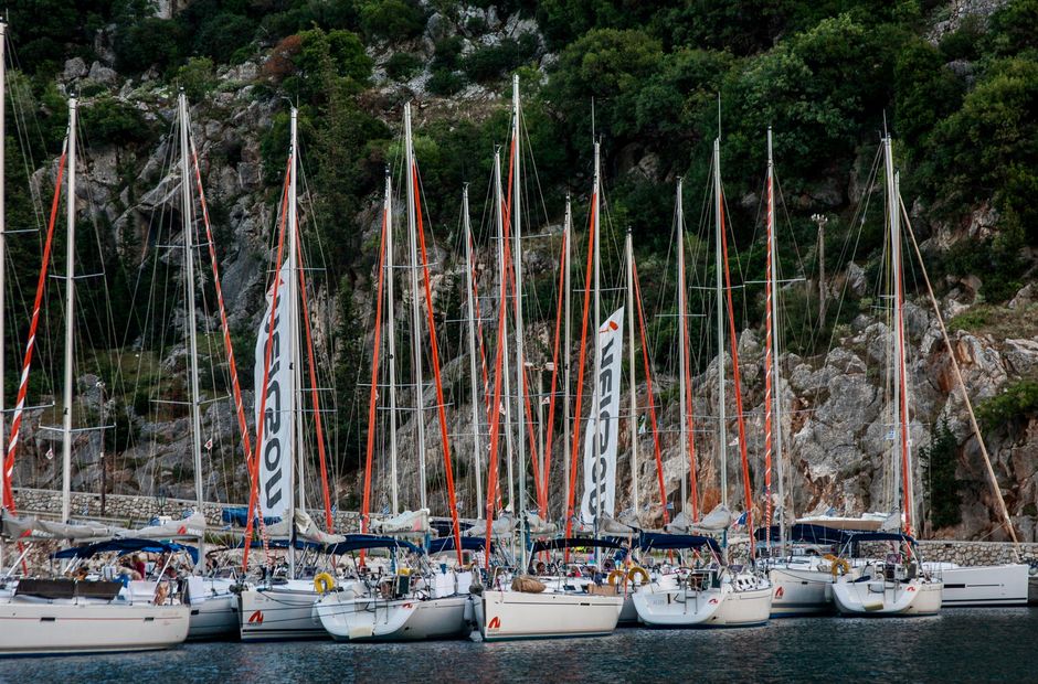 Unbeatable Full Day Yacht Tour in Catamaran Naxos Greece Review: An Unforgettable Day on the Aegean Review 2026 - A row of sailboats docked in a picturesque Greek harbor surrounded by rocky cliffs.