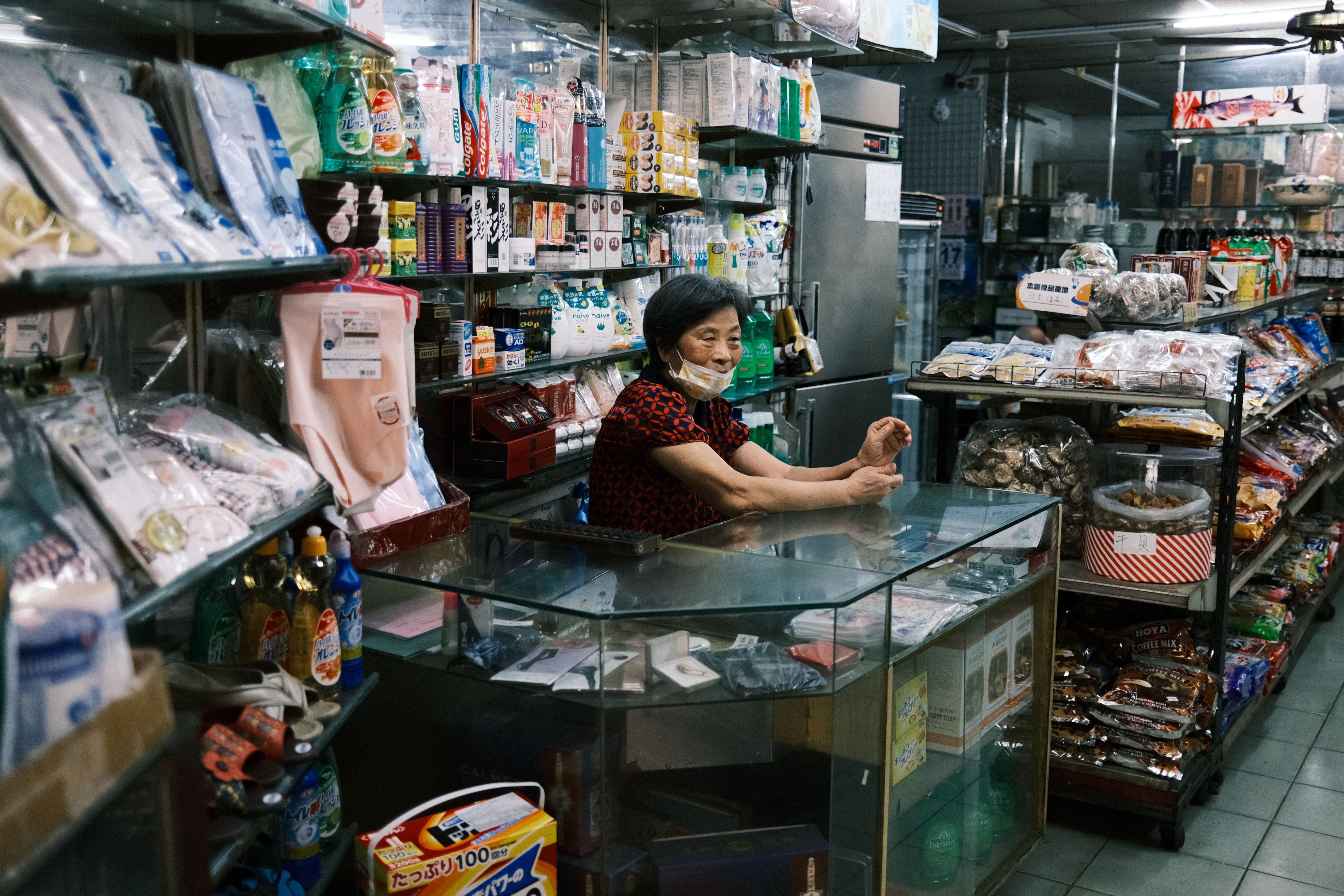 Person using foldable display stand in modern retail store with FMCG products
