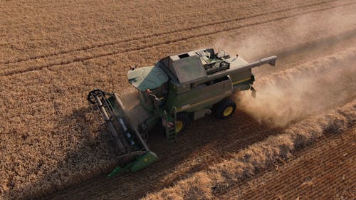 Green and Yellow Heavy Equipment on Brown Field