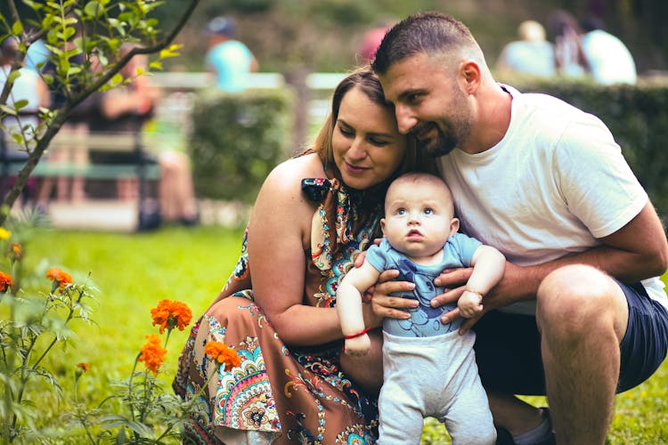 Family In A Garden Near A Flower