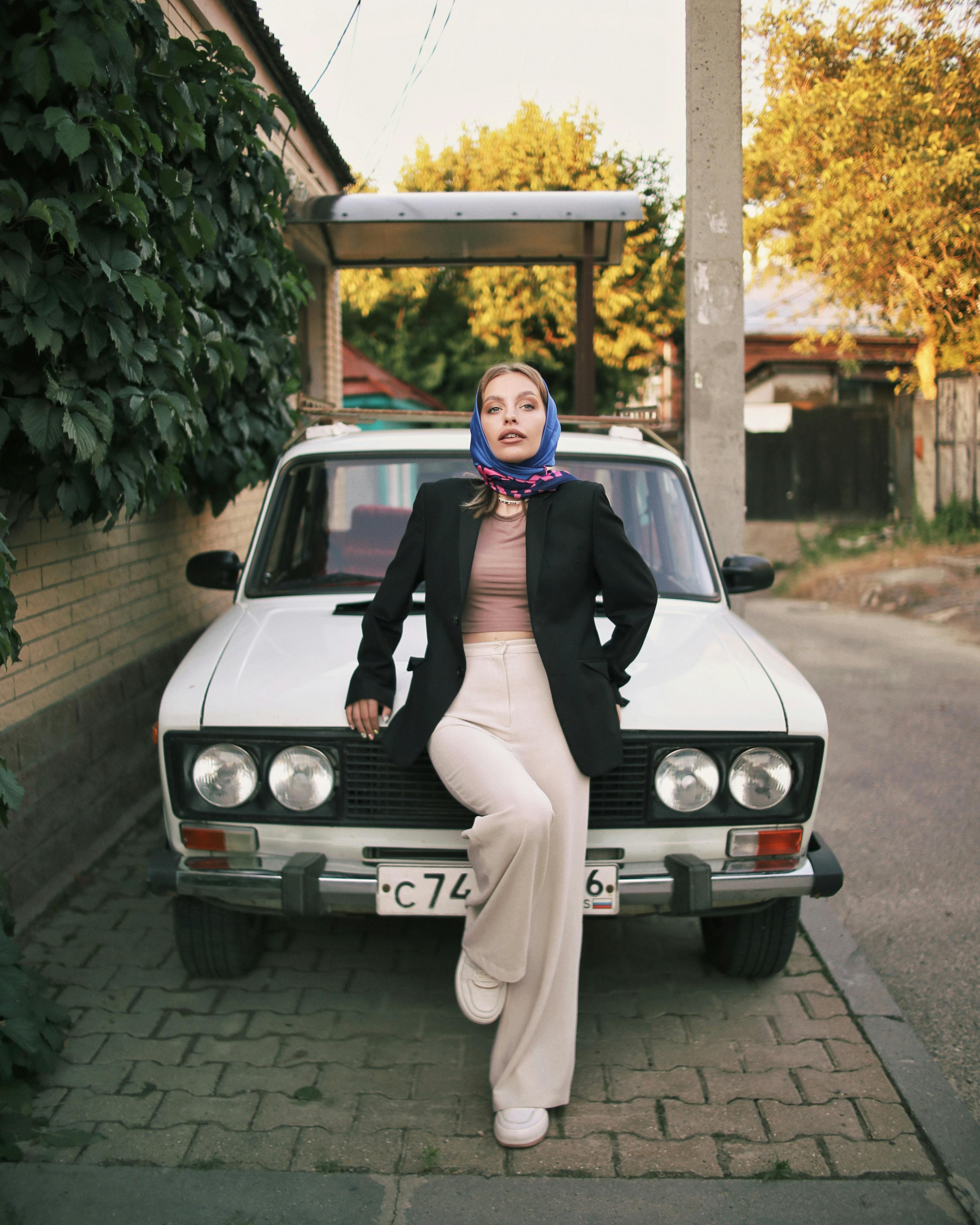 woman in shawl posing on car