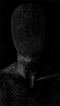 Abstract cracked sculpture on dark background, showcasing intricate textures. — photo by David Underland
