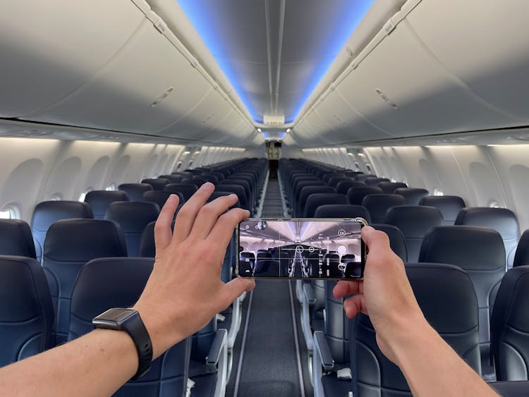 Person Taking Picture Of Empty Seats Inside An Airplane