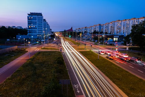 Cars on Road Near City Buildings during Night Time