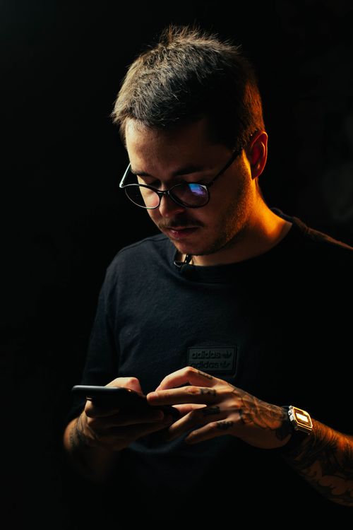 Free Portrait of a man using a smartphone in low light, focusing on technology. Stock Photo