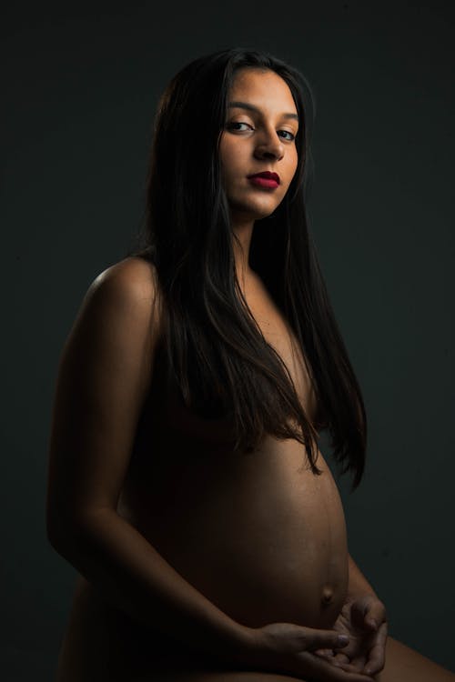 Long Hair Pregnant Nude - A Pregnant Woman With Long Hair Holding Belly While Sitting on Bed Â· Free  Stock Photo
