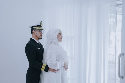 Elegant couple in wedding attire, featuring a pilot uniform, in a serene setting.