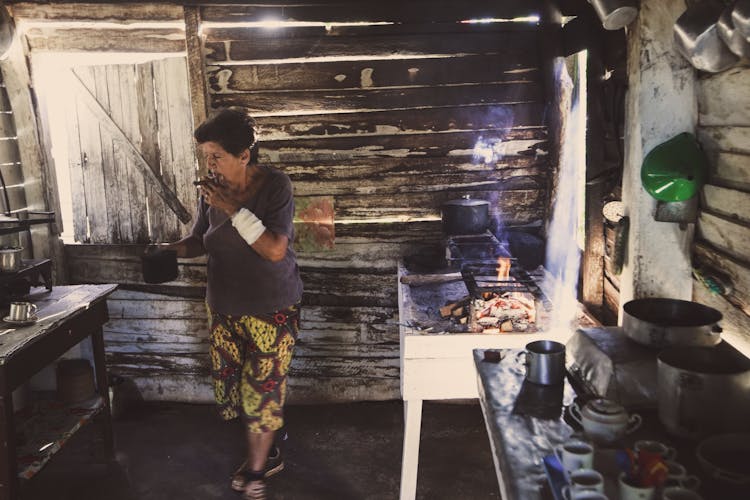 A Woman Smoking While Cooking In The Kitchen