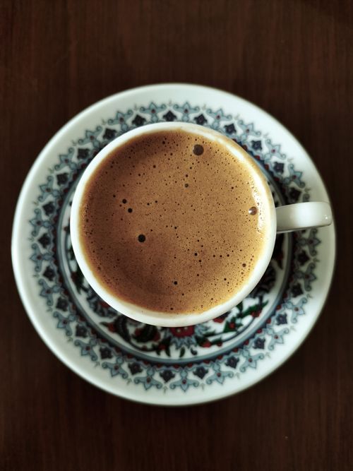 Free A rich, frothy coffee in a decorative cup and saucer from above. Stock Photo