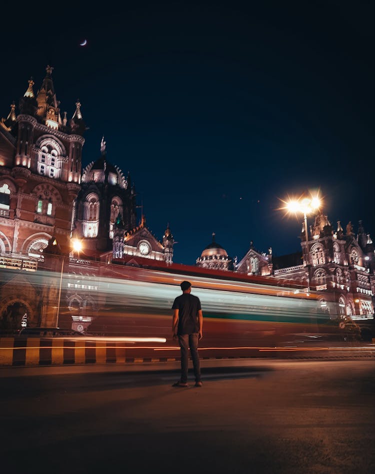 Man Standing Near Administration Building On Night Street