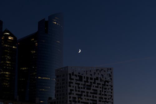 Crescent Moon Near High Rise Buildings during Night Time