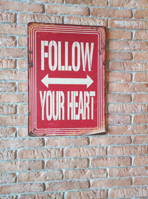 Free Red and white motivational sign on a vintage brick wall background. Stock Photo