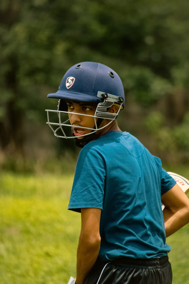 Boy Wearing A Helmet Playing Cricket