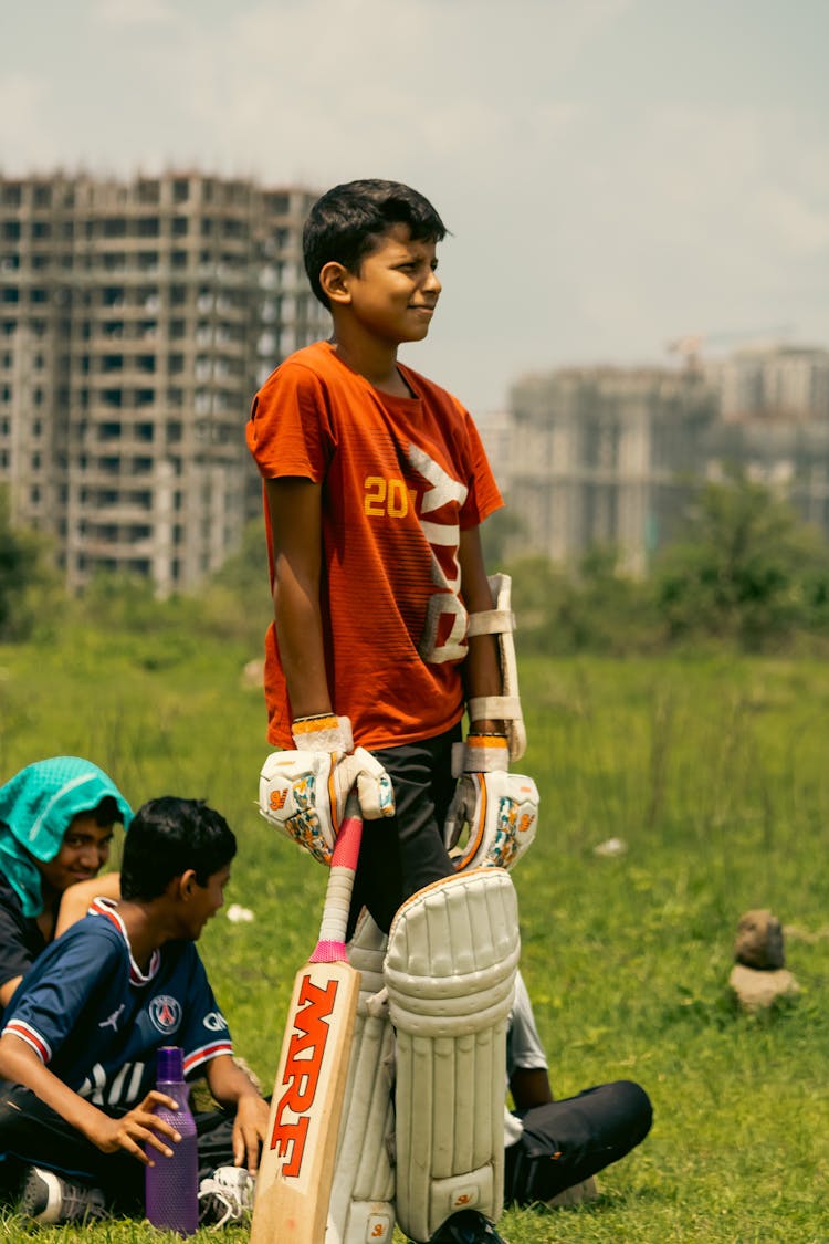 Boys Playing On A Grass And Blocks Of Flats In Background