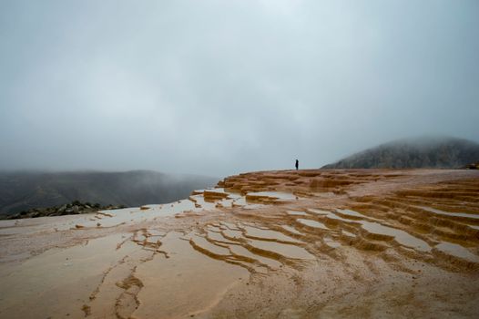 Discover the serene beauty of Badab-e Surt's terraced pools on a misty day in Mazandaran, Iran.