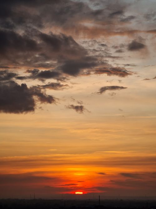 Free Captivating sunset with dramatic clouds creating a warm and serene atmosphere. Stock Photo