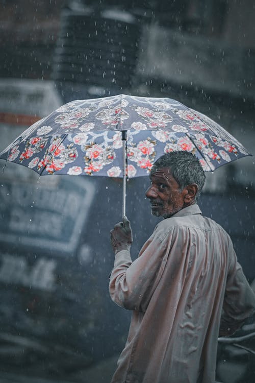 Man Using an Umbrella in a Rainy Day
