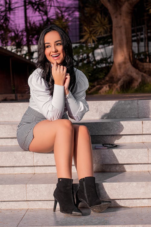 Woman in White Long Sleeve Shirt sitting on the Stairs