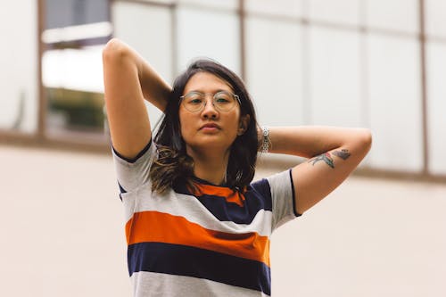 Woman in Striped Shirt with Hands on Head