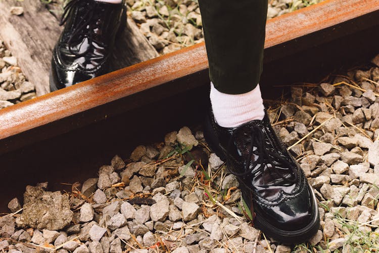 Close-up Of Leather Shoes Stepping On Rocks