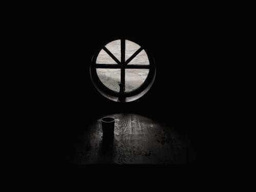 Grayscale Photography of Cup Beside Closed Window in Empty Room