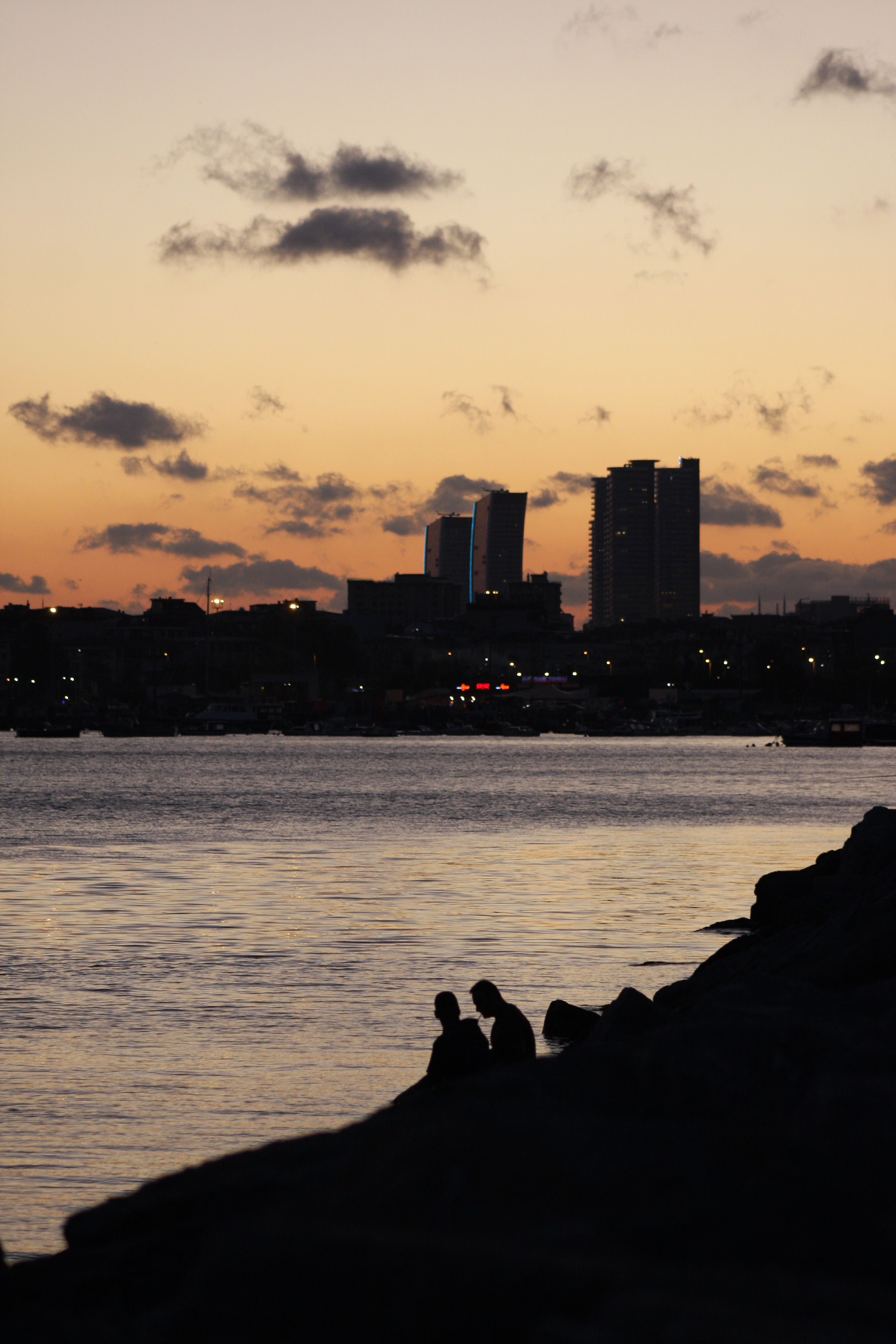 Silhouetted Skyscrapers by a Body of Water at Sunset · Free Stock Photo