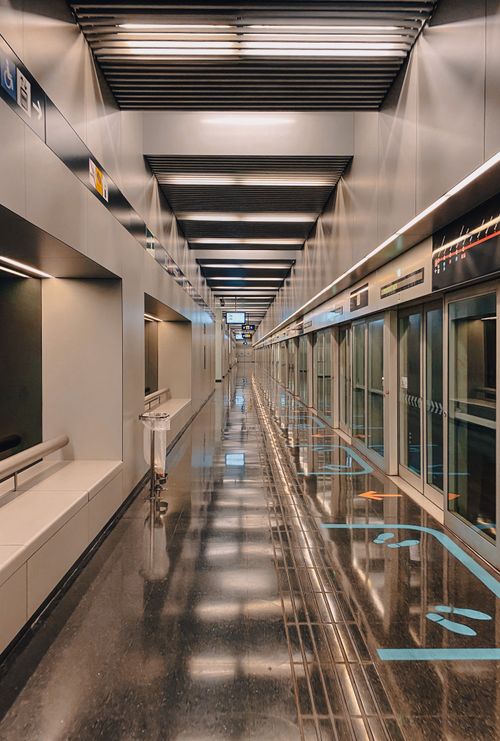 Free Empty and sleek modern station walkway in Barcelona, Spain, with reflective floor and overhead lighting. Stock Photo