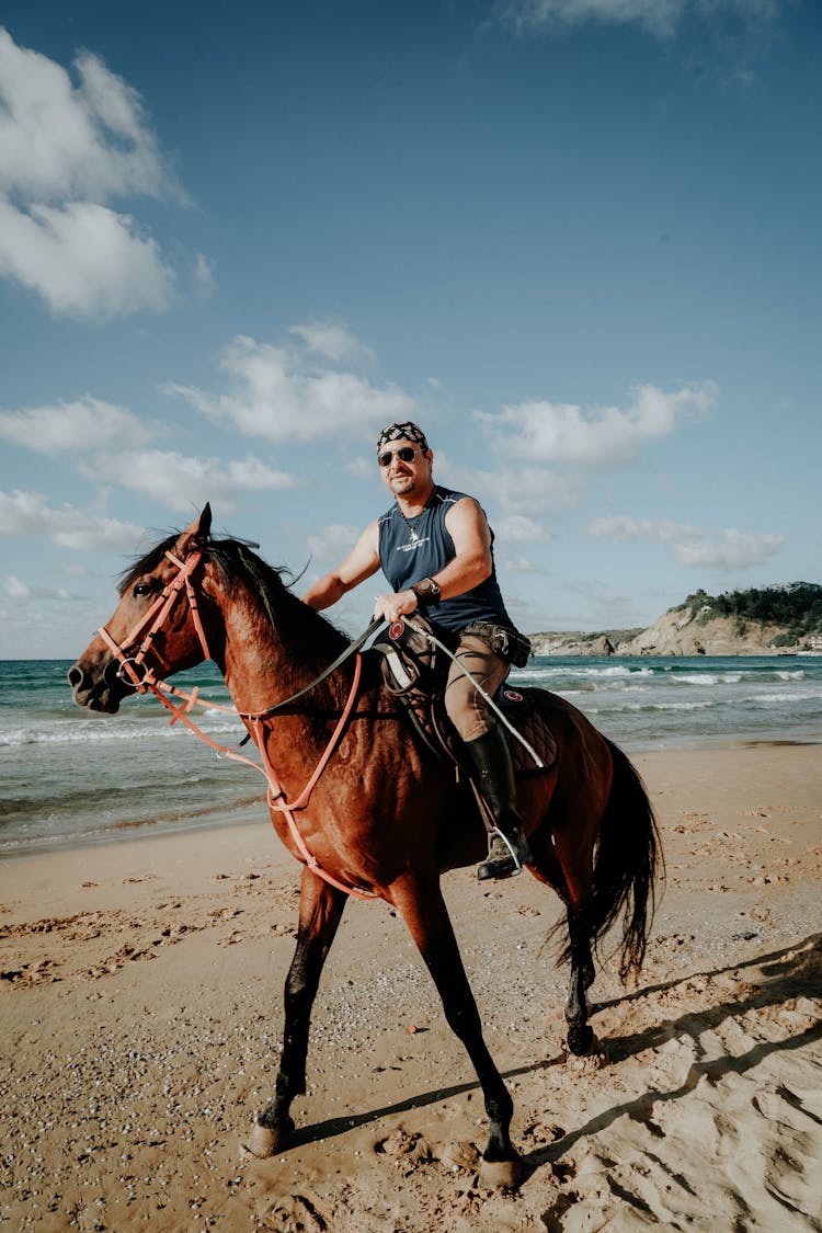 A Man Riding A Horse At The Beach 