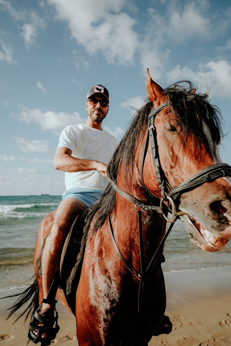 Man Riding A Horse At The Beach