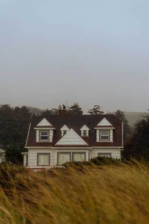 Free Elegant house surrounded by misty fields and trees, showcasing serene natural beauty at twilight. Stock Photo